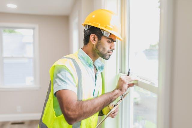 man in vest checking windows