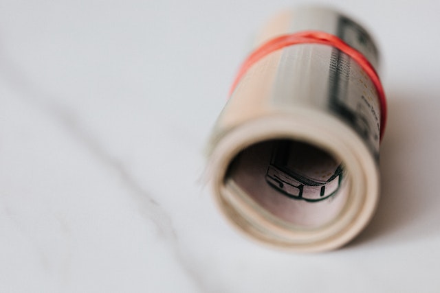 a roll of cash with a red elastic