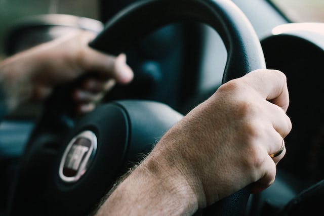 person-holding-steering-wheel-parking-car