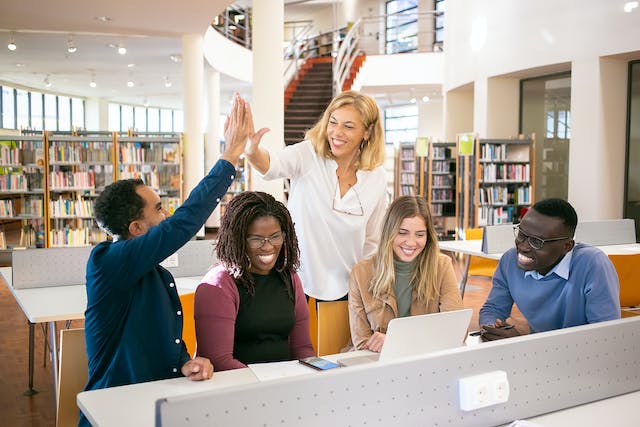 five students studying at a university library